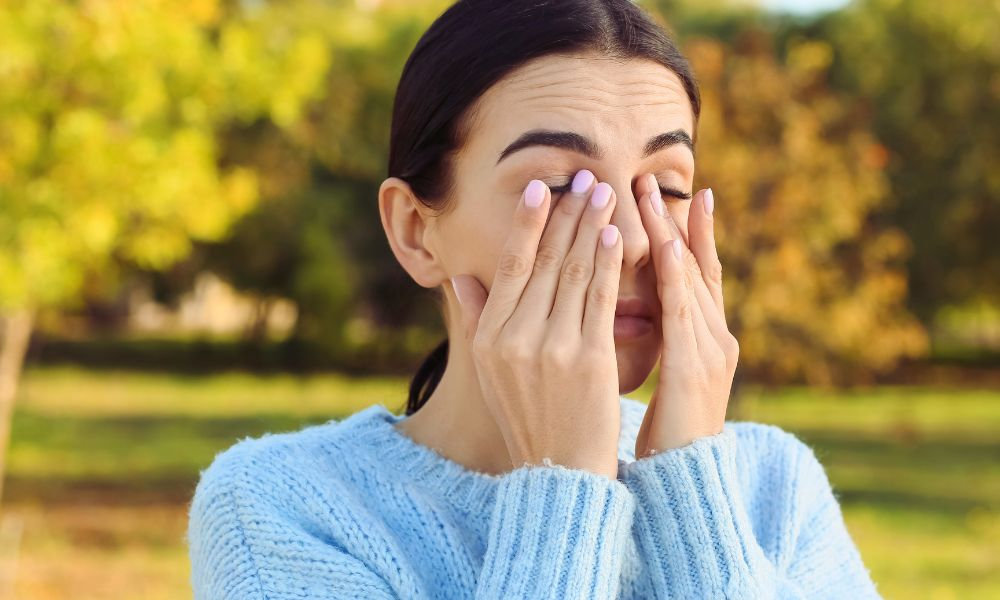  Žena si trie oči kvôli sezónnej alergii
