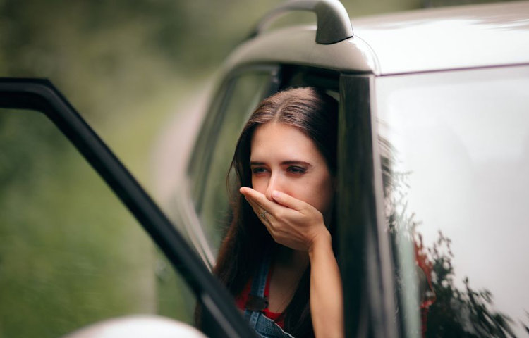 Žena s pocitom na zvracanie v aute ako typický príznak kinetózy