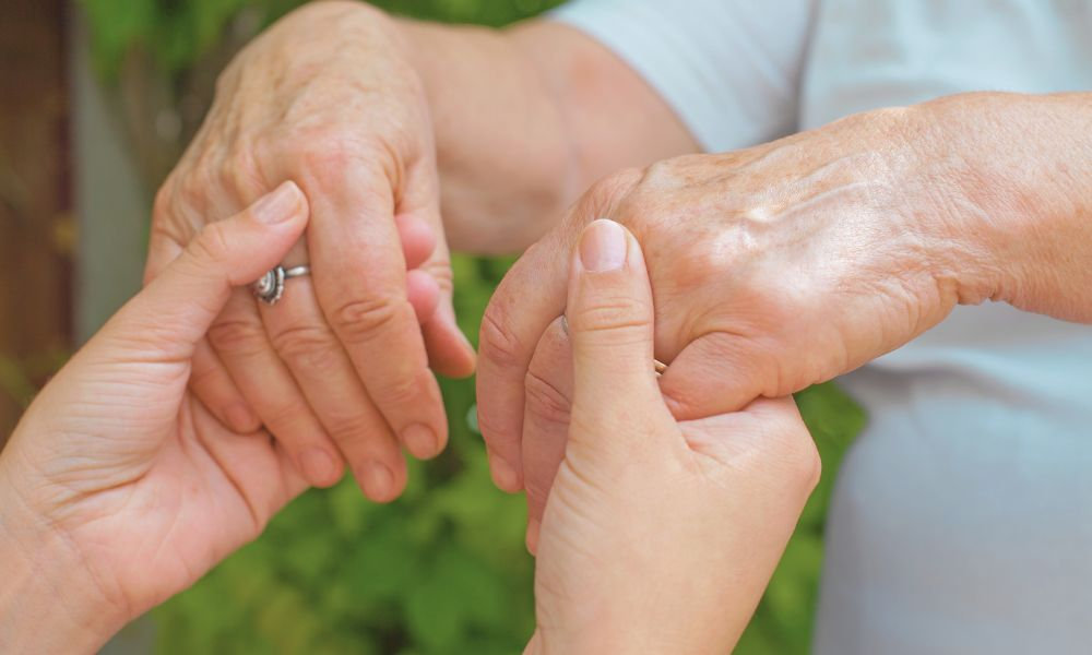  Dve ruky poskytujúce podporu staršej osobe – liečba Parkinsonovej choroby s dôrazom na starostlivosť